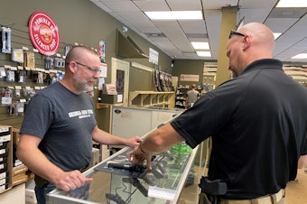 caption: "Most of it is is new gun owners," says Michael Weeks (left), a gun store owner in Gainesville, Ga. By one estimate, Americans have bought nearly 3 million more guns than usual since March.