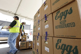 caption: Cases of eggs from Cal-Maine Foods, Inc., await to be handed out by the Mississippi Department of Agriculture and Commerce employees at the Mississippi State Fairgrounds in Jackson, Miss., on Aug. 7, 2020.
