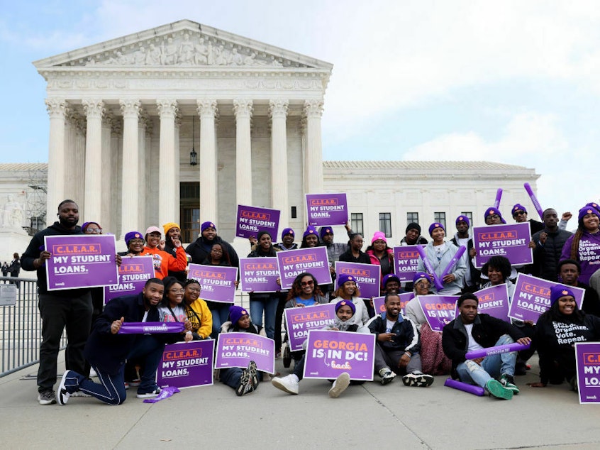 caption: Student loan borrowers and advocates gather Tuesday for a rally during the Supreme Court's arguments on President Biden's student debt relief plan.