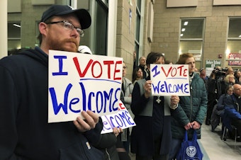 caption: In this Dec. 9. 2019, file photo, residents in support of continued refugee resettlement hold signs at a meeting in Bismarck, N.D.