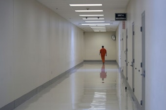 caption: A detainee walks in a hallway on Tuesday, September 10, 2019, at the Northwest Detention Center, recently renamed the Northwest ICE Processing Center, in Tacoma.