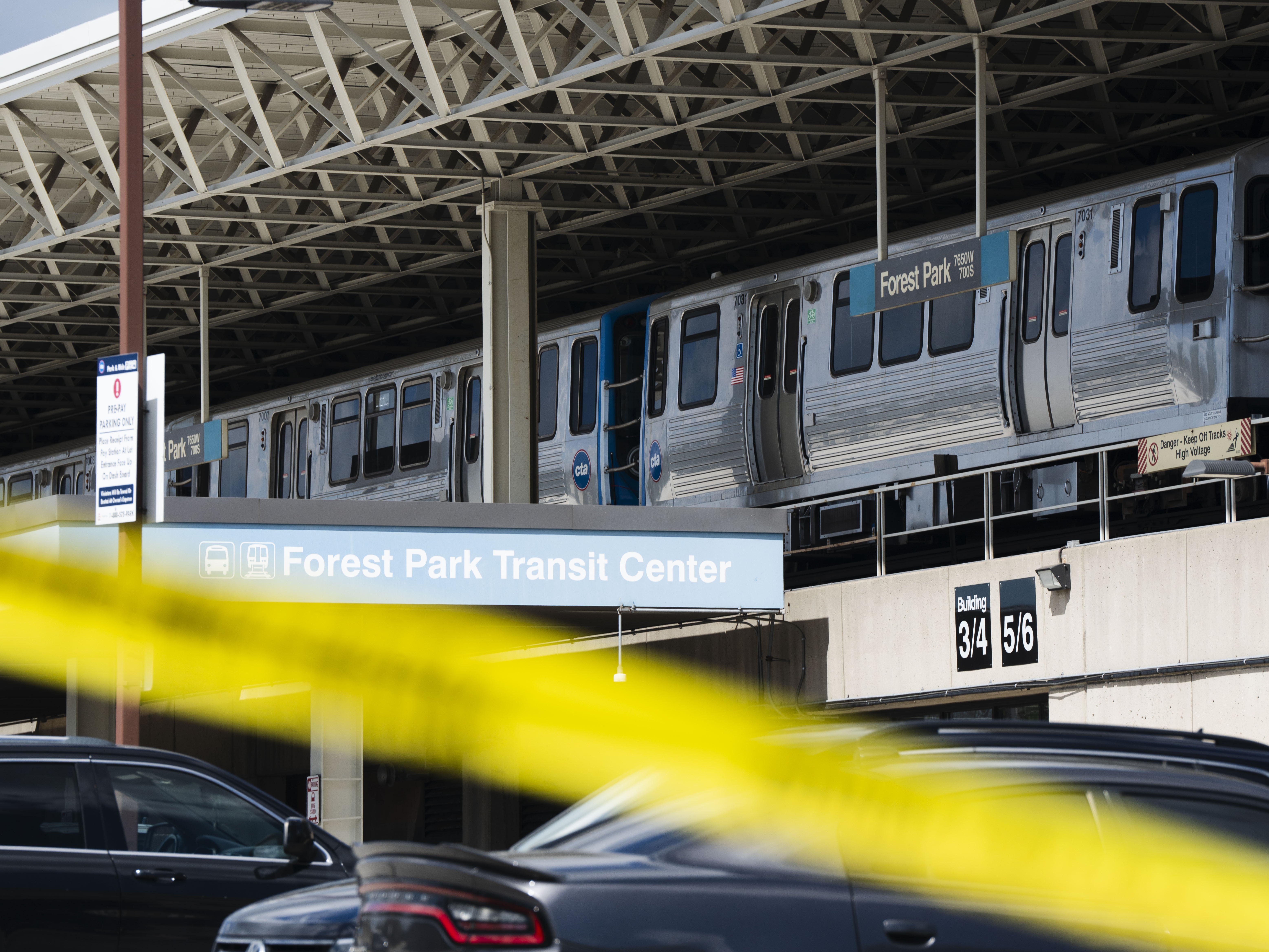 caption: Yellow tape blocks off the parking lot of the Forest Park Blue Line train station in Forest Park, Ill., after four people were fatally shot on the train early Monday, Sept. 2, 2024. 