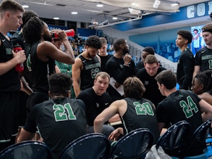 caption: Dartmouth Big Green gather for a team talk during their game against Columbia Lions in their NCAA men's basketball game on February 16, 2024 in New York City.