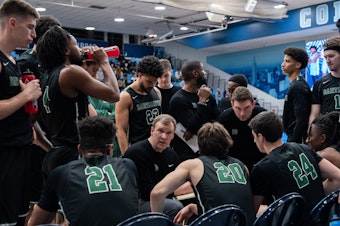 caption: Dartmouth Big Green gather for a team talk during their game against Columbia Lions in their NCAA men's basketball game on February 16, 2024 in New York City.