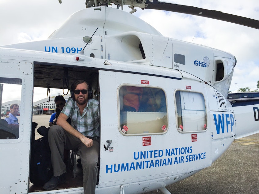 caption: Dr. Eugene Richardson in a helicopter during the Ebola outbreak in Sierra Leone, where he worked as a clinical lead for Partner in Health's response to the outbreak. He is the author of the new book <em>Epidemic Illusions: On the Coloniality of Global Public Health.</em>