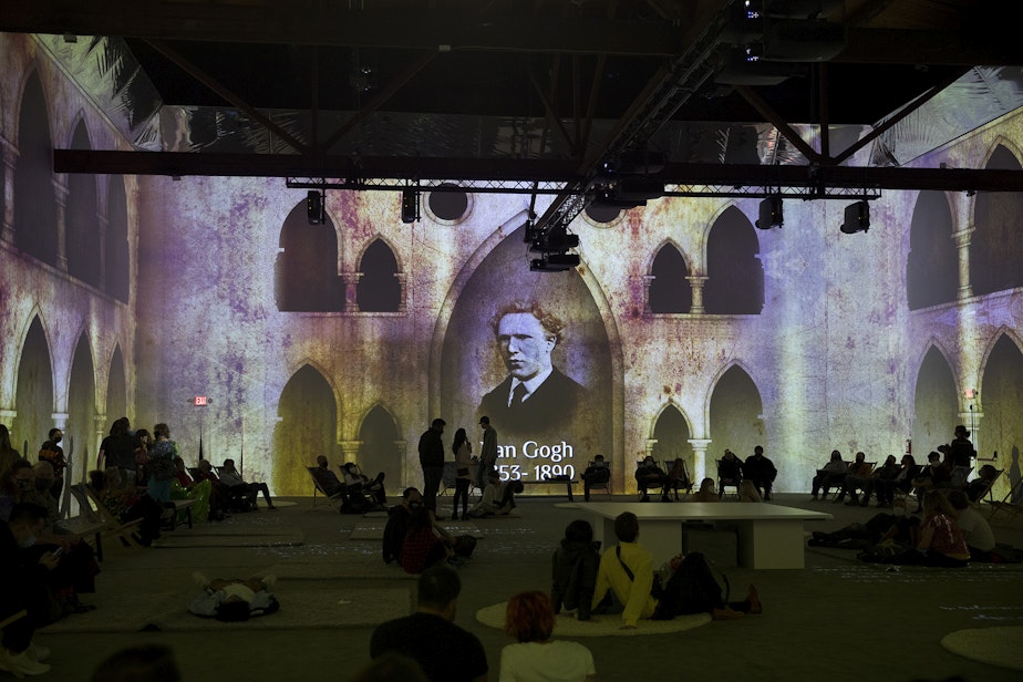 caption: Patrons take in various projections of Van Gogh's work in the 360-degree 8,000 square foot immersive room on Wednesday, October 27, 2021, at the exhibit along Occidental Avenue in Seattle's SODO neighborhood.