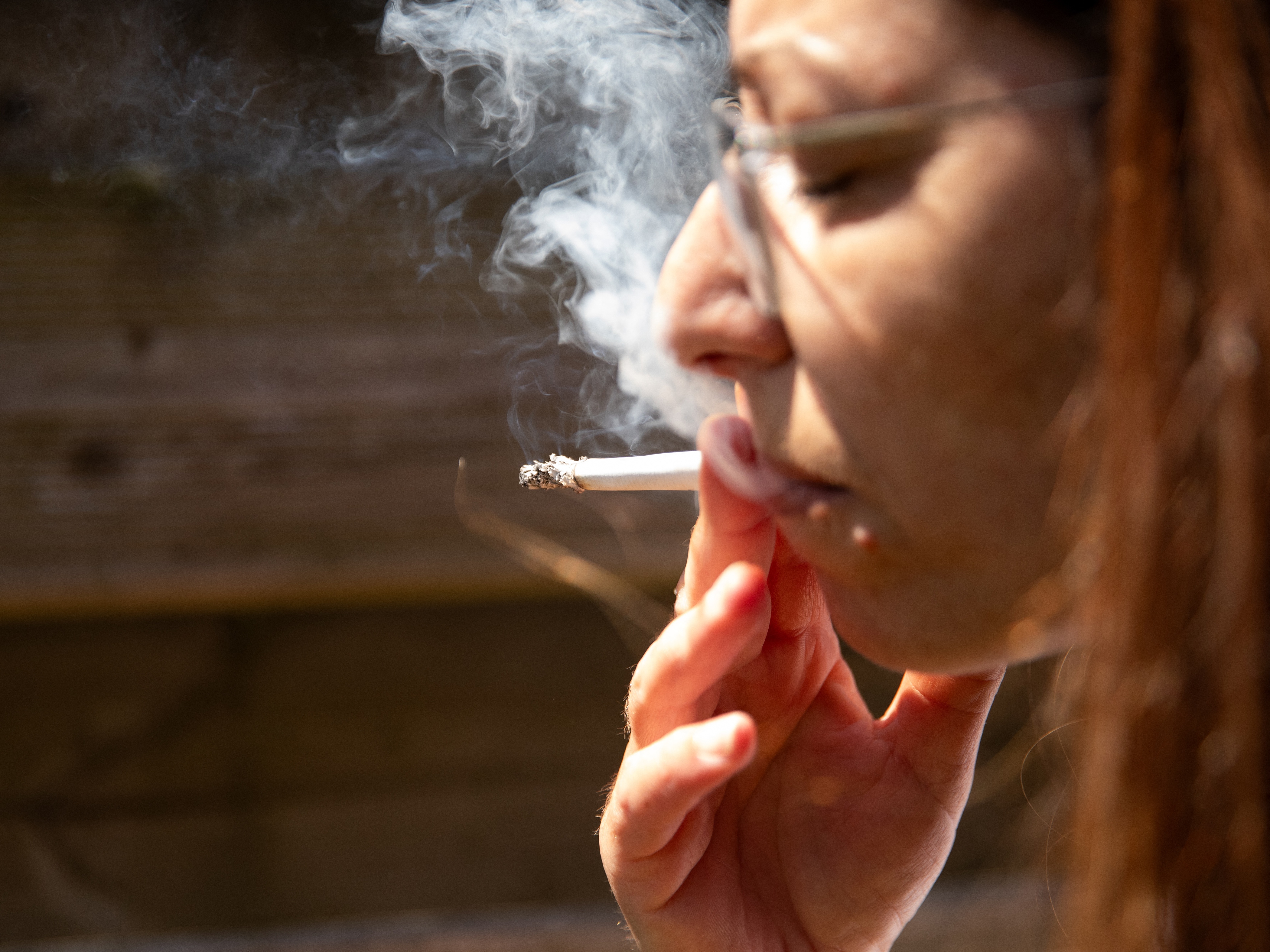 caption: A woman smokes a cigarette at Kerlouan in Brittany in France on May 30. The country is banning smoking in many public places.