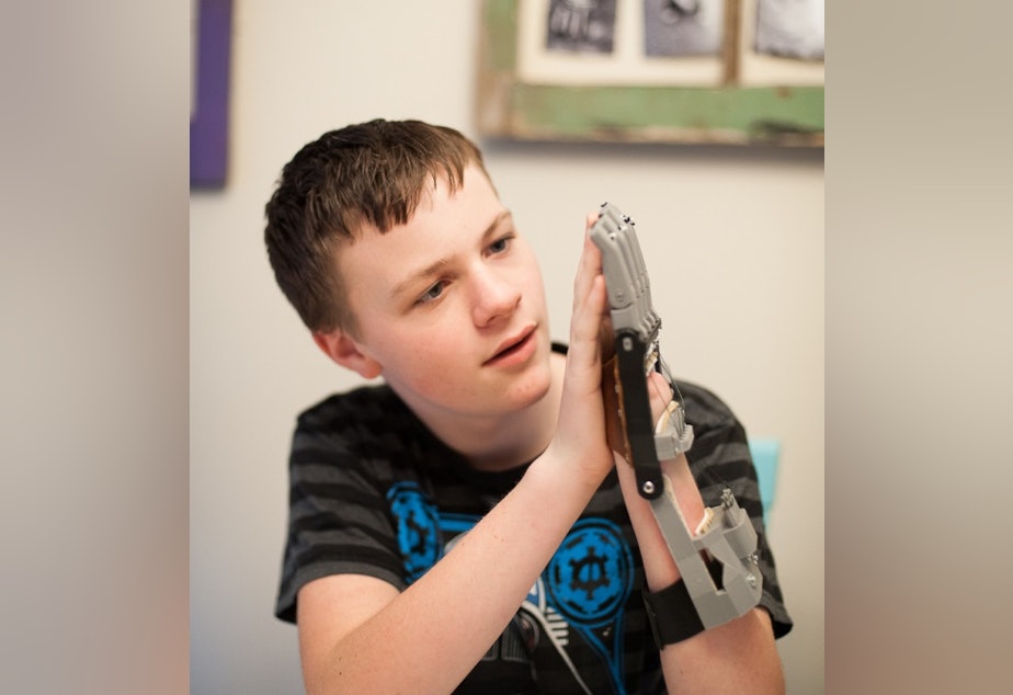 caption: A boy learns to use a hand printed for him by Ivan Owen. 