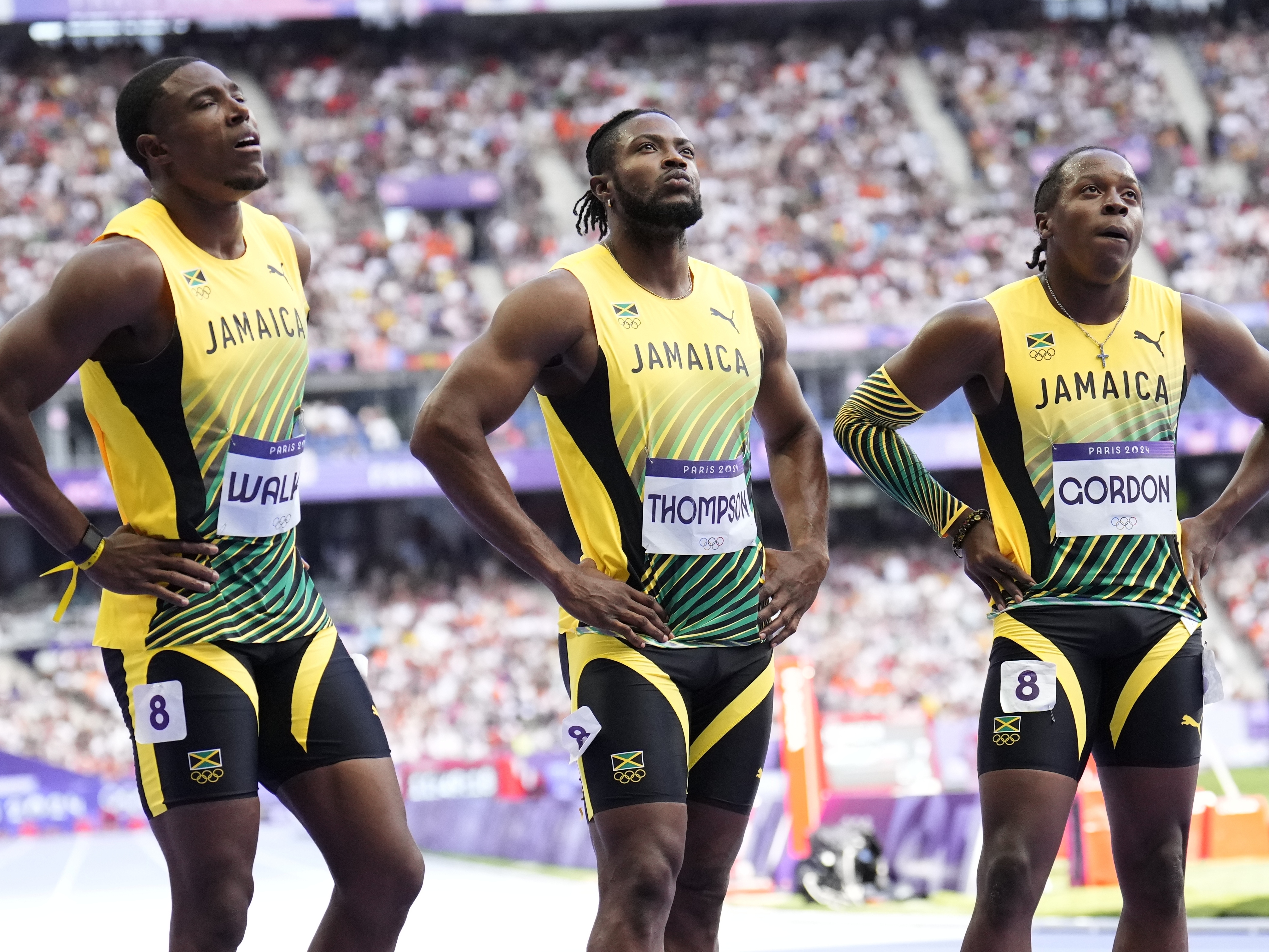 caption: Members of Jamaica's men's 4x100-meter relay team react following their heat at the Paris Olympics on Thursday, in Saint-Denis, France.