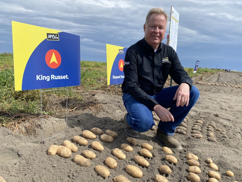 caption: Ken Luke, a manager with McCain Foods, shows off some of the old standby potato varieties, along with some of the new, like the fresh “King Russet,” at a recent field day in Quincy.