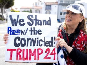 caption: A supporter outside a fundraising event for Donald Trump in San Francisco on Thursday isn't put off by his conviction.