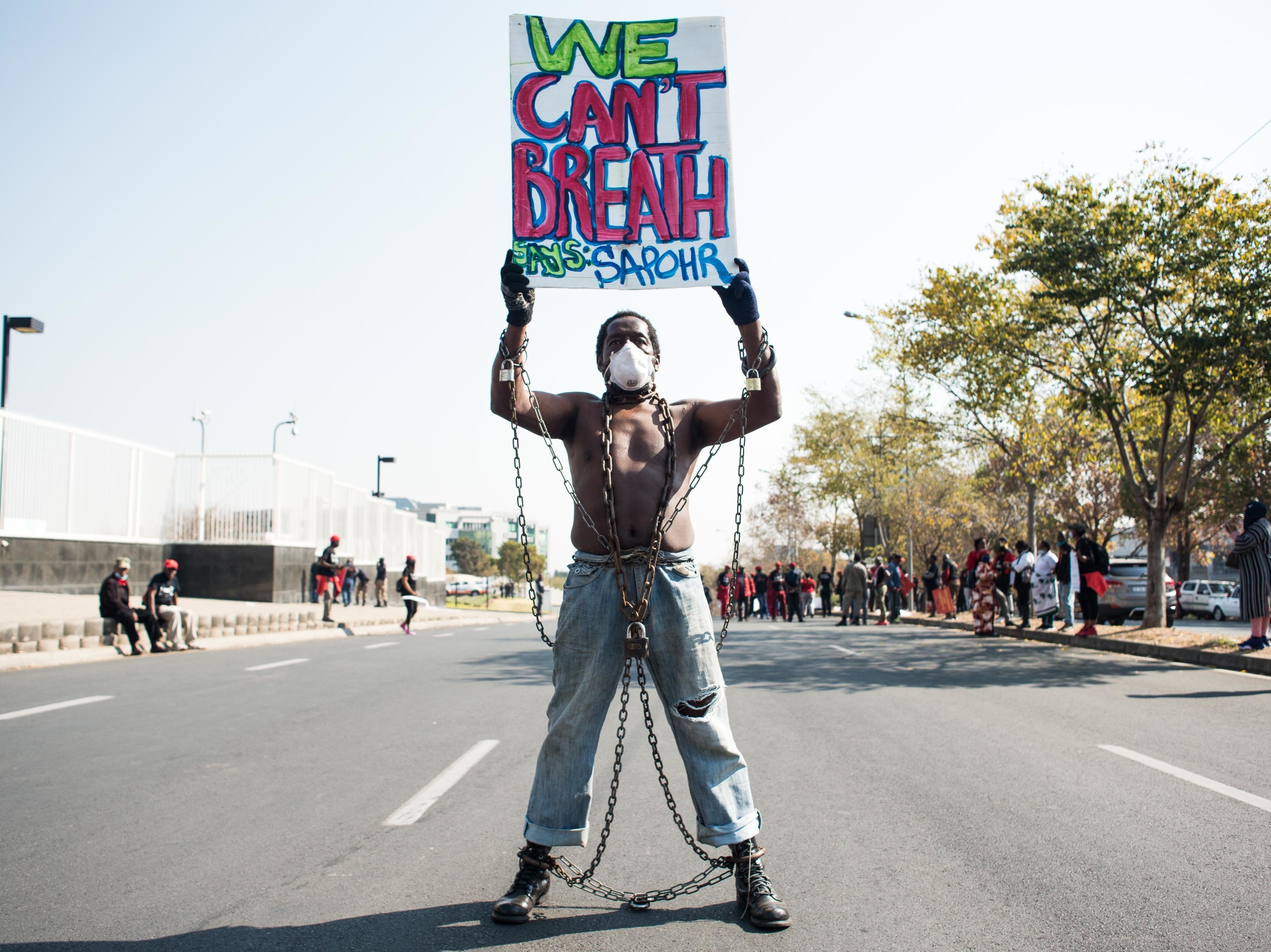 caption: Members of Economic Freedom Fighters (EFF) protest against the death of George Floyd outside U.S. Consulate in solidarity with Black Lives Matter movement on June 8, 2020 in Sandton, South Africa.