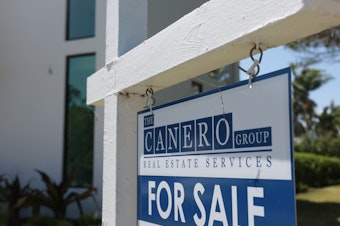 caption: A 'For Sale' sign is posted on the lawn in front of a home on March 15, 2024, in Miami, Fla. The National Association of Realtors announced that it had reached a nationwide $418 settlement of claims that the industry had conspired to keep agent commissions high.