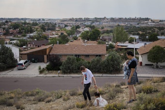 caption: Dr. Chris Hoover (left) and Dr. Connie Liu (right) walk through their home with their children Taro, 3, and Hiro, 4 months, in Gallup, N.M. On a short reporting trip across the Southwest, NPR met very different families and asked them the same simple question: What's been keeping you at night?