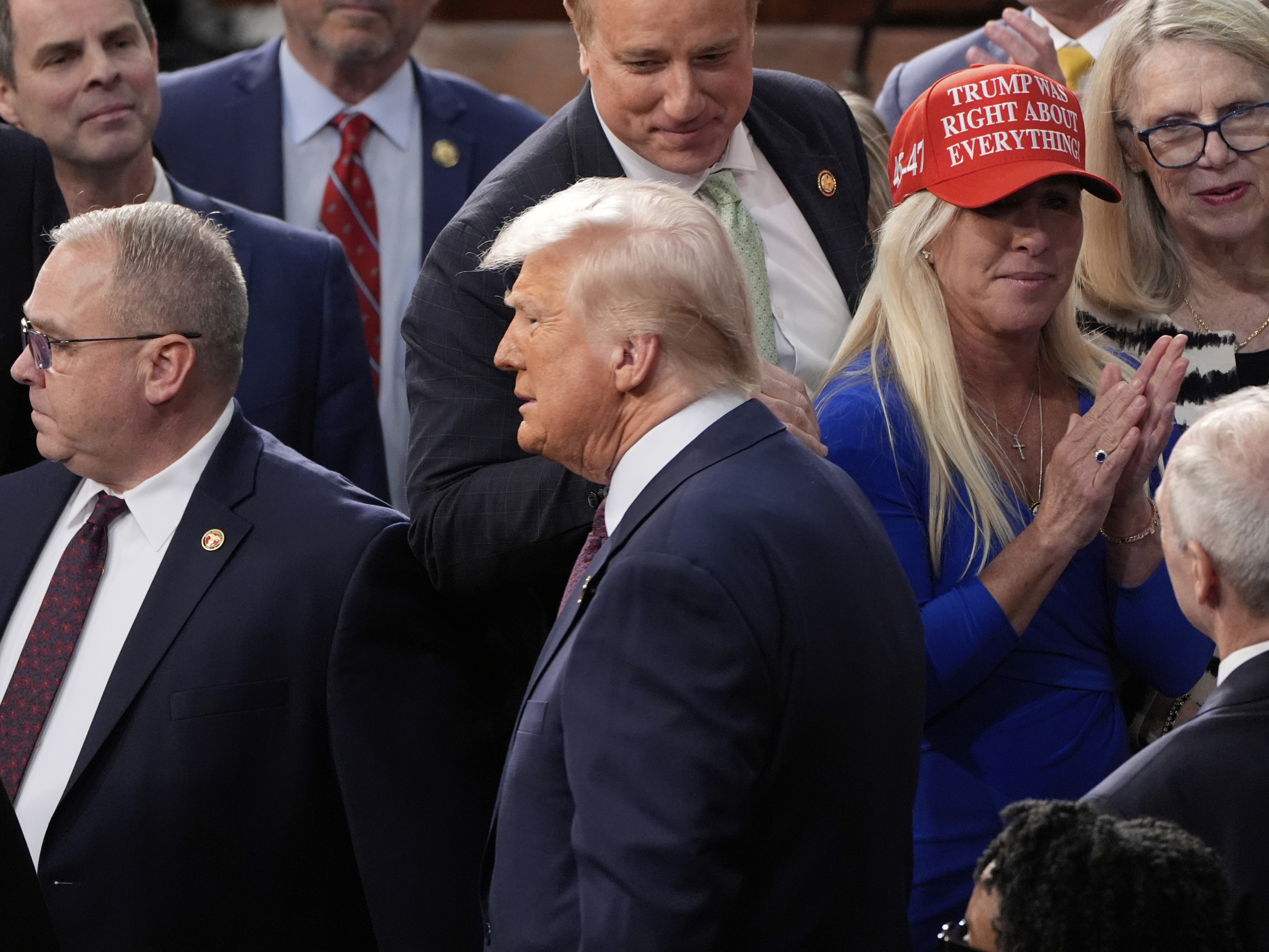 caption: President Trump arrives after being greeted by Rep. Marjorie Taylor Greene, R-Ga., to address a joint session of Congress at the Capitol in Washington on March 4.