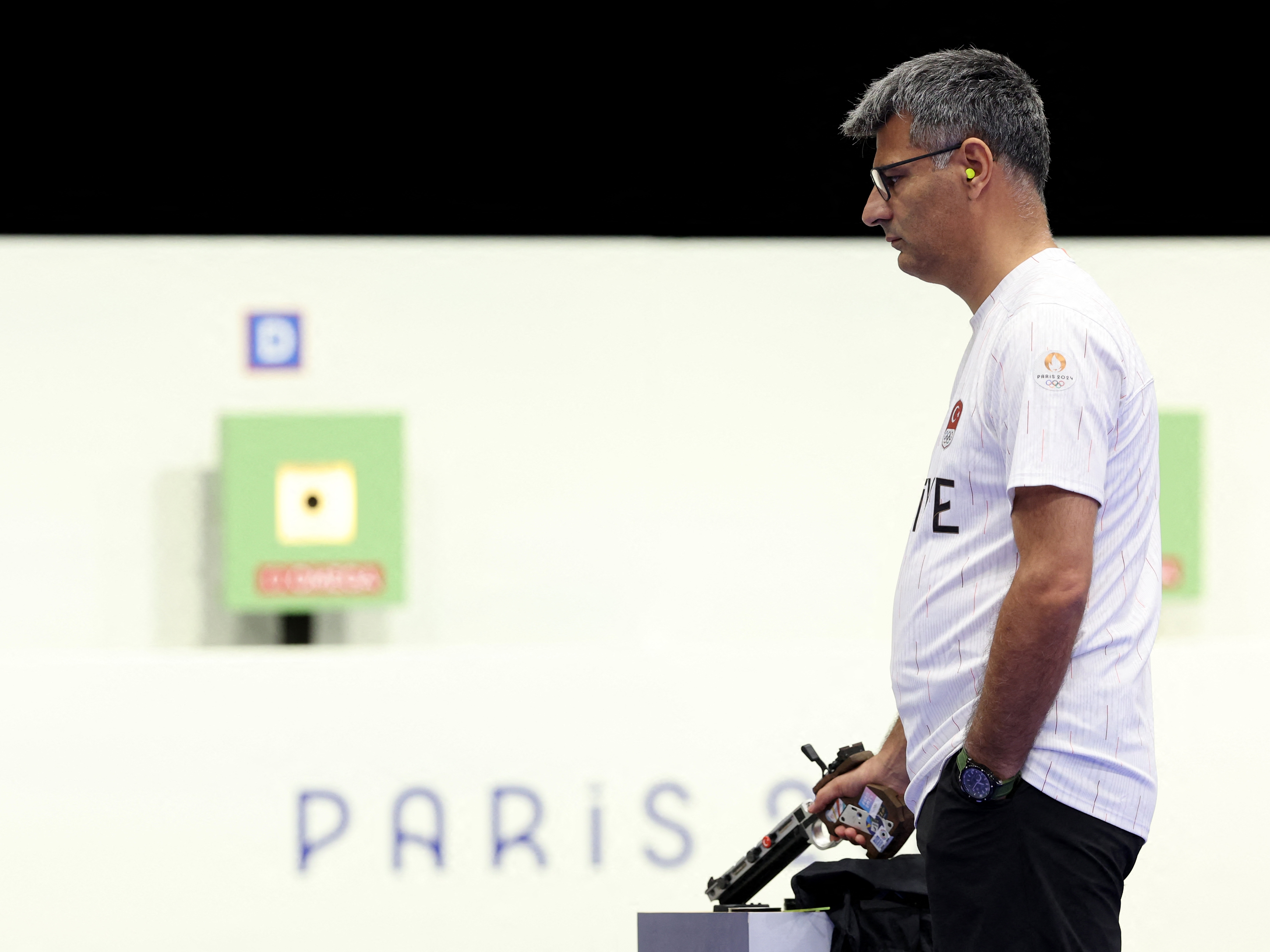 caption: Turkey's Yusuf Dikec, pictured competing in the shooting 10m air pistol mixed team gold medal match at Chateauroux Shooting Center on Tuesday, went viral for his casual look. 