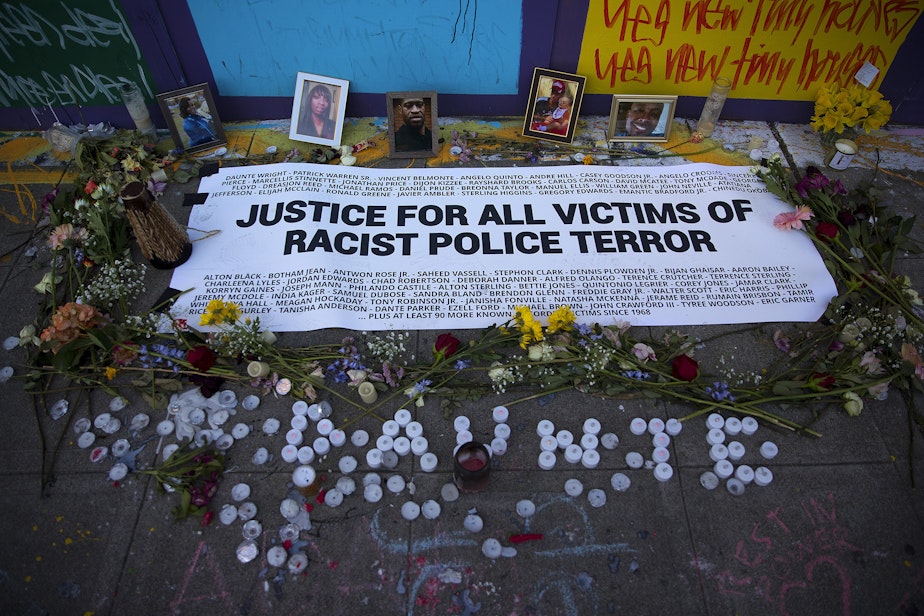 caption: Photographs of Breonna Taylor, Charleena Lyles, George Floyd, Daunte Wright and Manuel Ellis are shown included in a vigil that remains near the intersection of 11th Avenue and East Pine Street on Tuesday, April 20, 2021, in Seattle. 