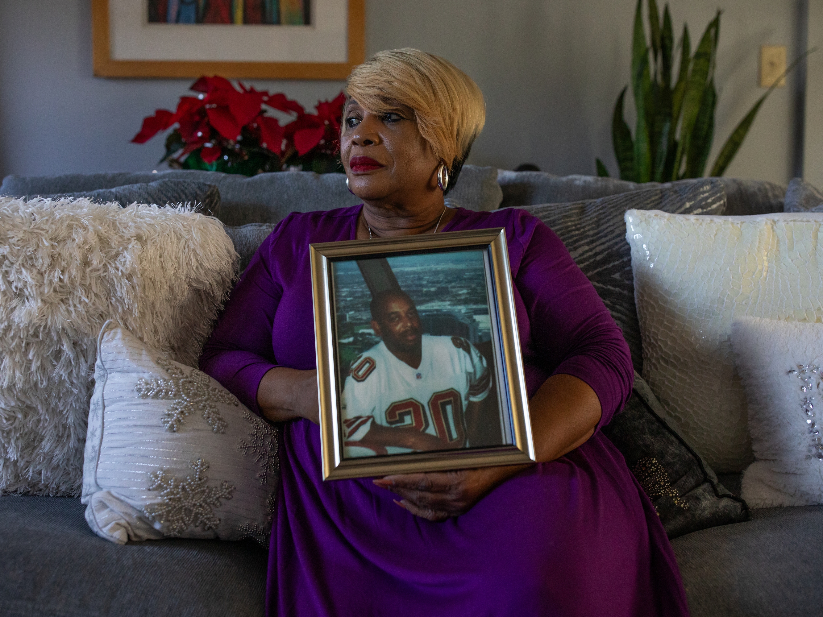 caption: Melinda Mattocks-Ushry holds a photo of her brother Kelvin “Chuck” Mattocks at her home in New Bern, N.C., on Dec. 5, 2023. 