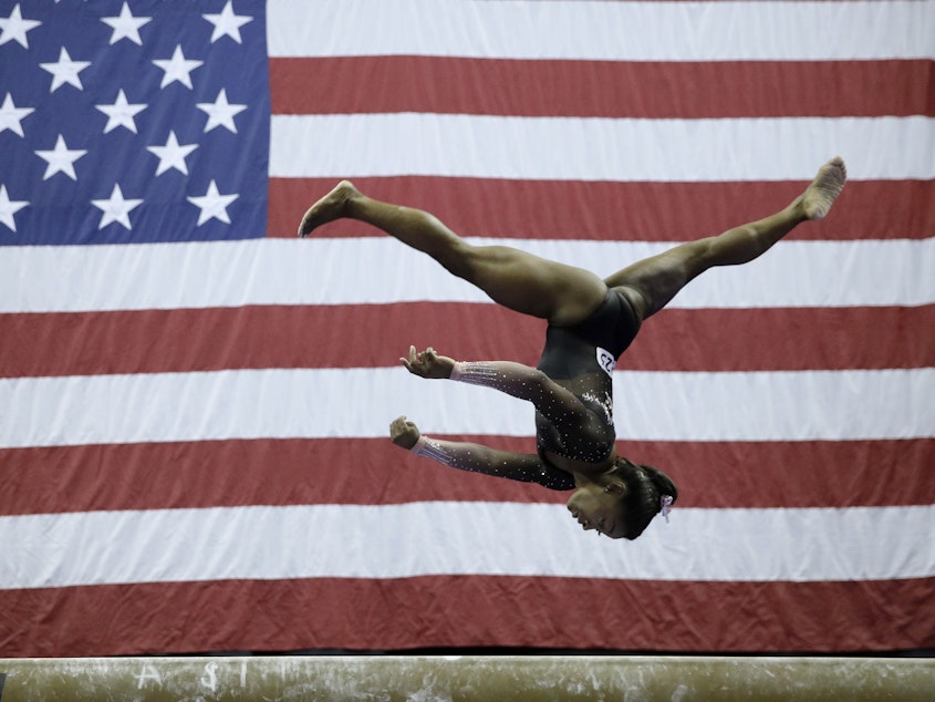 caption: Simone Biles competes on the balance beam at the U.S. Gymnastics Championships on Sunday. The reigning world champion is the first woman to stick the landing after two flips and three full twists.