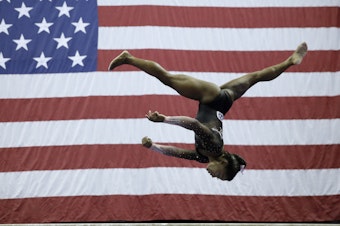 caption: Simone Biles competes on the balance beam at the U.S. Gymnastics Championships on Sunday. The reigning world champion is the first woman to stick the landing after two flips and three full twists.