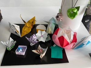 caption: Volunteers at the center for media at the Tokyo Olympics made origami designs, including cranes and flowers.