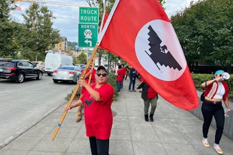 caption: Leandra Arreguin Valencia demonstrates in Seattle Thursday afternoon for the right for workers to unionize at Windmill Farms in Sunnyside, WA.