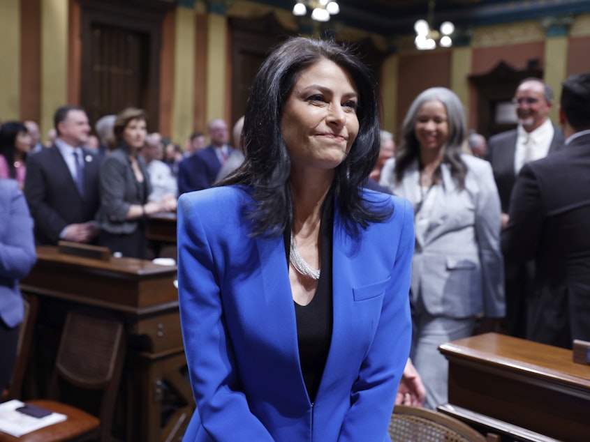 caption: Michigan Attorney General Dana Nessel walks to her seat before the State of the State address on Jan. 25 at the state Capitol in Lansing, Mich.