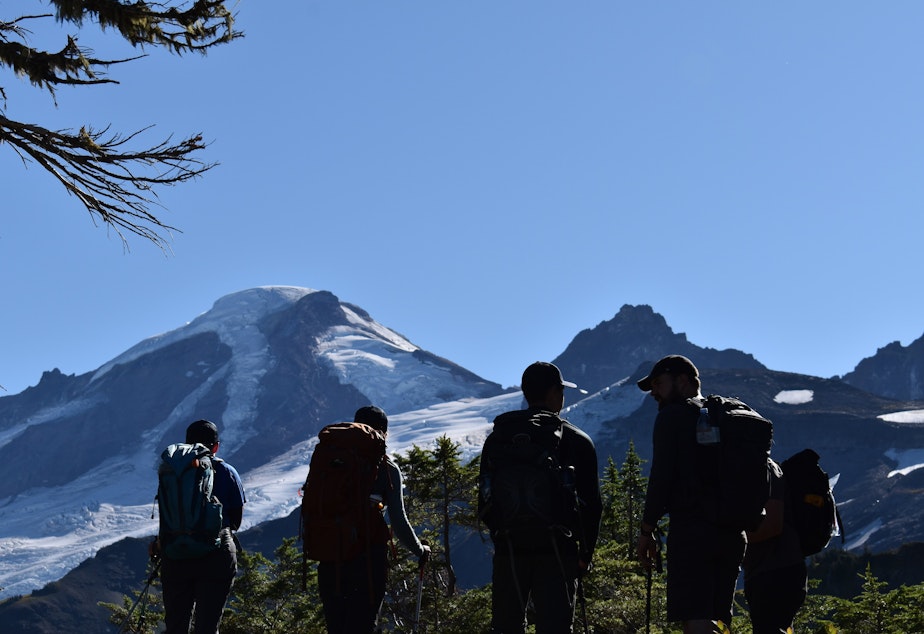 Caption: A group of researchers take a break on a trip to replace batteries at a seismic monitoring station on Mount Baker on September 16, 2021.