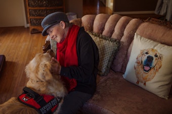 caption: Peggy Gibson sits in her living room with her service dog, Rocky, in West Jefferson, N.C., last November. Gibson says Rocky, a diabetic alert dog, isn't able to work well in public.