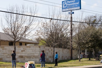 caption: Anti-abortion-rights activists pray outside a Planned Parenthood clinic that offers abortions in 2016 in Austin. Texas has suspended most abortions during the coronavirus pandemic.