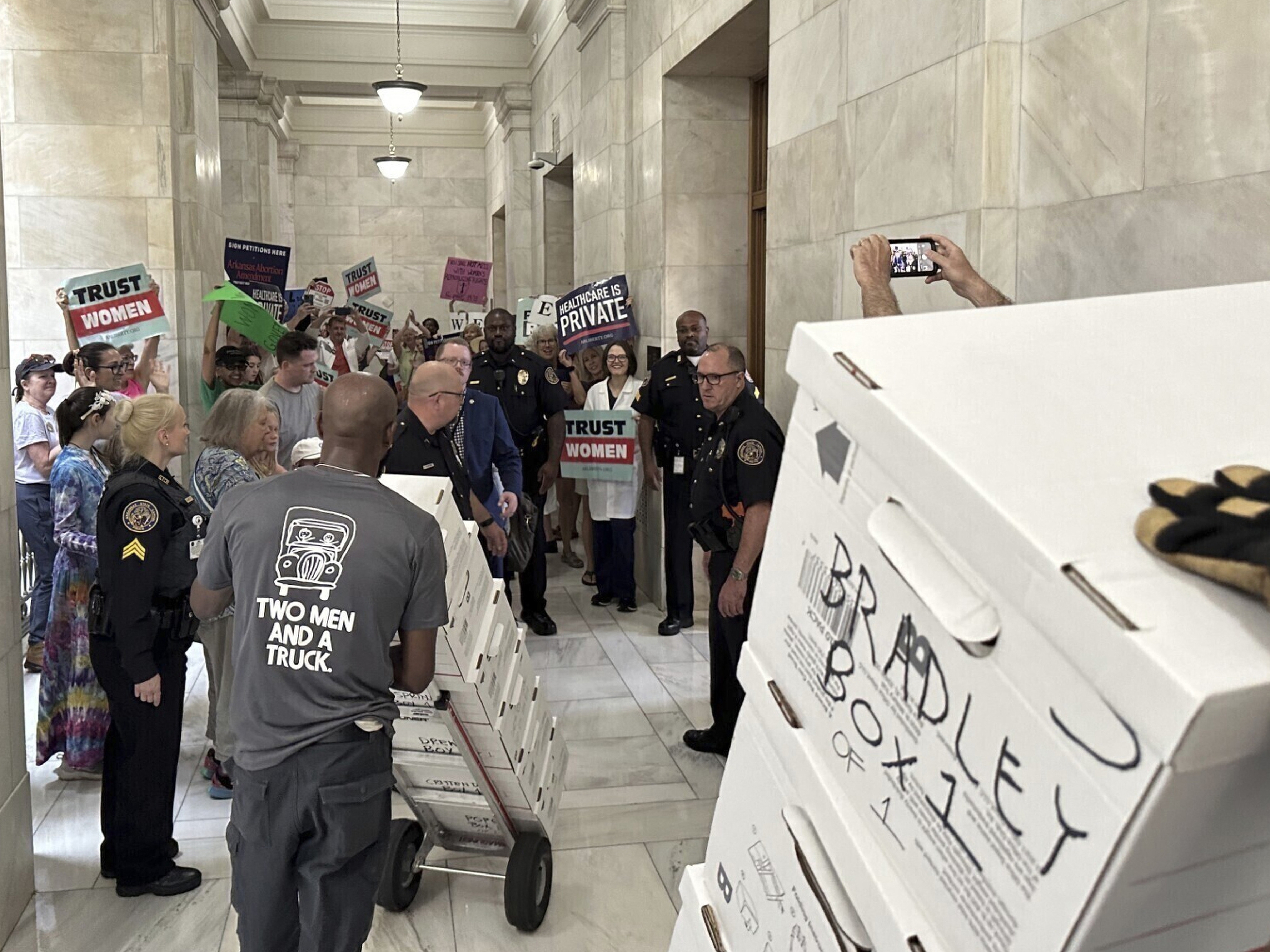 caption: Boxes containing signatures supporting a proposed ballot measure to scale back Arkansas' abortion ban are delivered to the state Capitol in Little Rock, Ark., on July 5, 2024. Arkansas lawmakers this year passed new restrictions on citizen-led ballot measures.