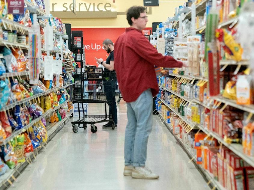 caption: Shoppers browse at a grocery store in Washington, D.C. Retail sales dipped in February after surging in the previous month.