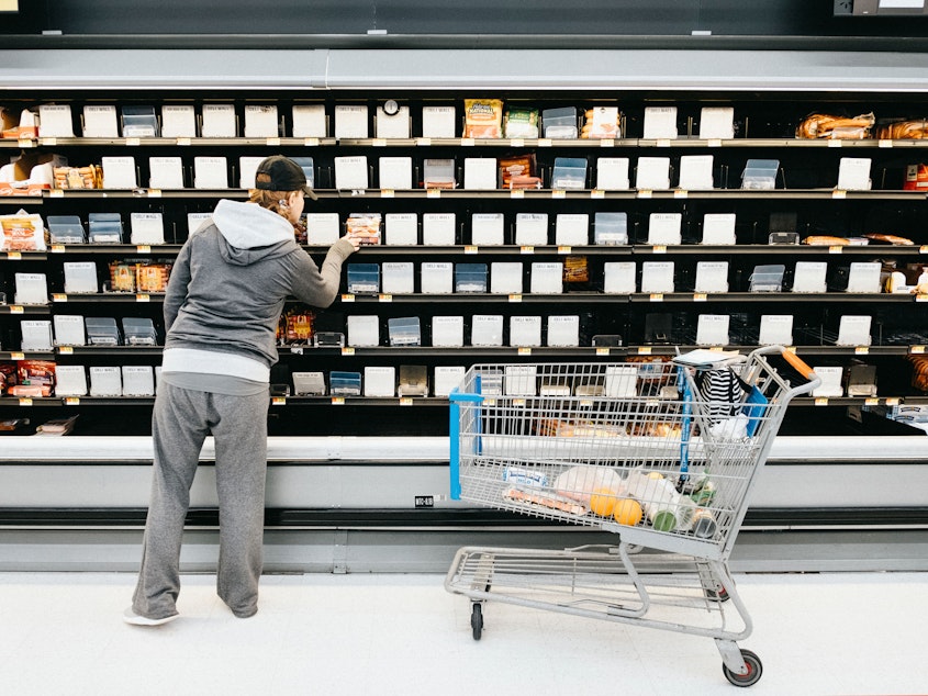caption: A person shops in front of the empty shelves in the deli section of a Walmart Supercenter in Nashville on Saturday.