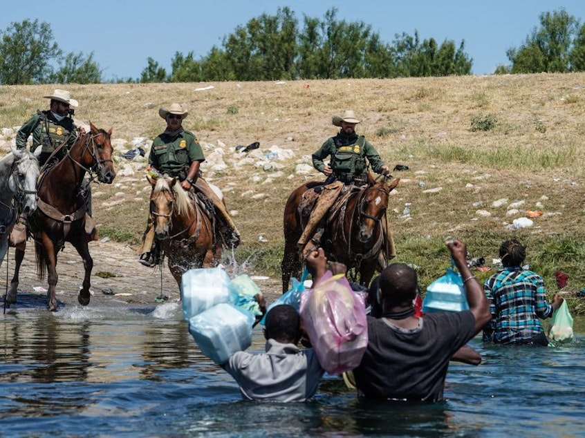 caption: The woman identified in court papers as Esther (far right) was among Haitian migrants who say they were threatened by Border Patrol agents on horseback last September as they tried to return to a makeshift camp in Del Rio, Texas.