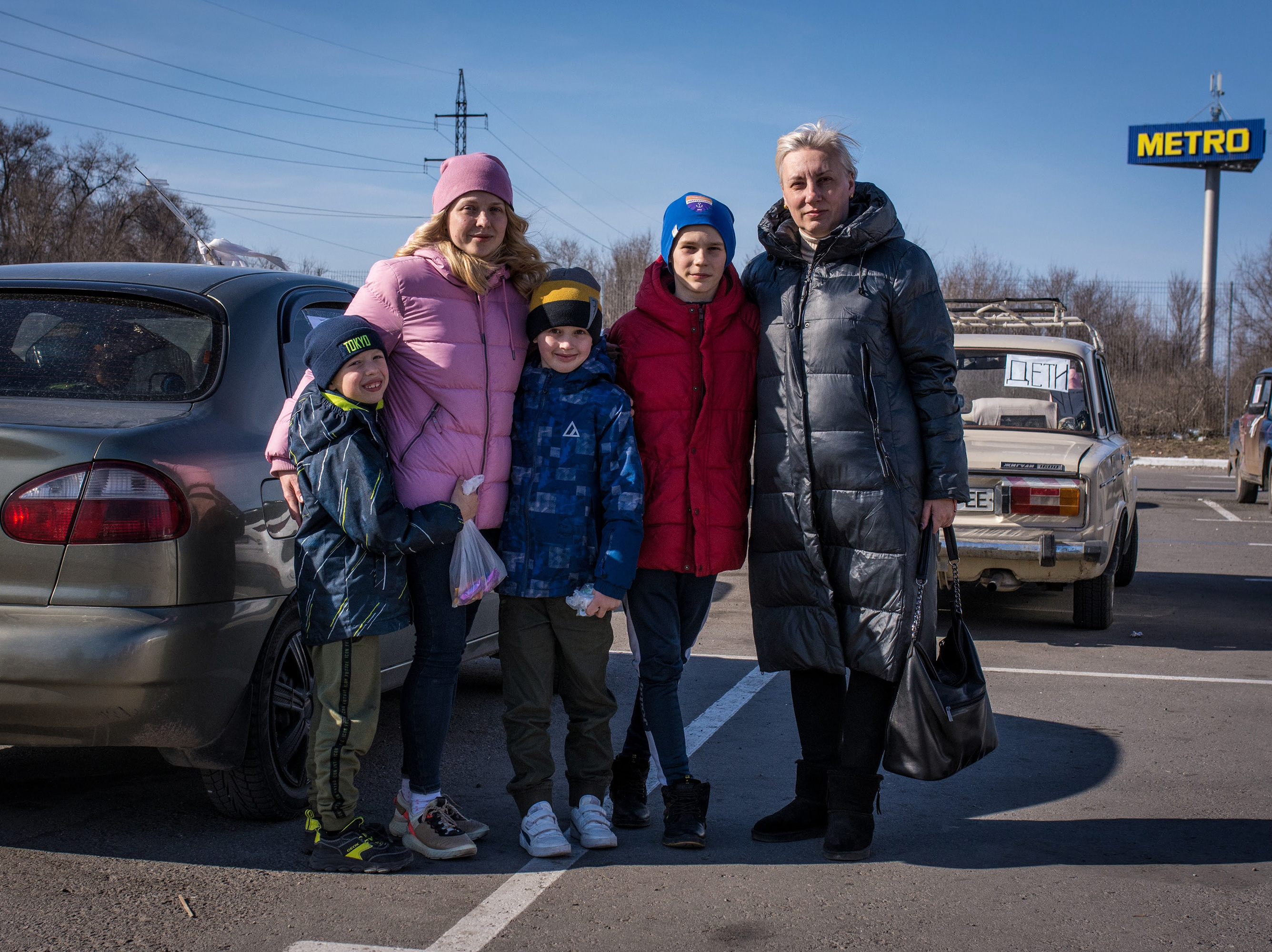 caption: Angelina Voychenko (left) and her children and Yuliya Bortnik (right) and her son fled Mariupol after hiding for weeks in the basement of Voychenko's parents' home, with no electricity, phone service or heat, as the building shook from fighter jets and explosions. When they emerged to buy food, what they saw made them decide to leave: destroyed buildings, looted stores, no food in sight.