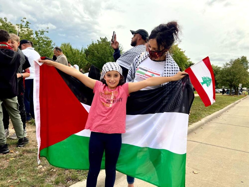 caption: Huwaida Arraf and her daughter Mayaar at a rally in Dearborn, Michigan. (Deepa Fernandes/ Here & Now)