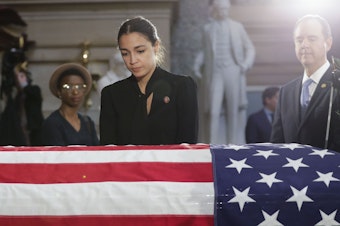 caption: Rep. Alexandria Ocasio-Cortez, D-N.Y., stops to pay her respects at the Capitol on Thursday.