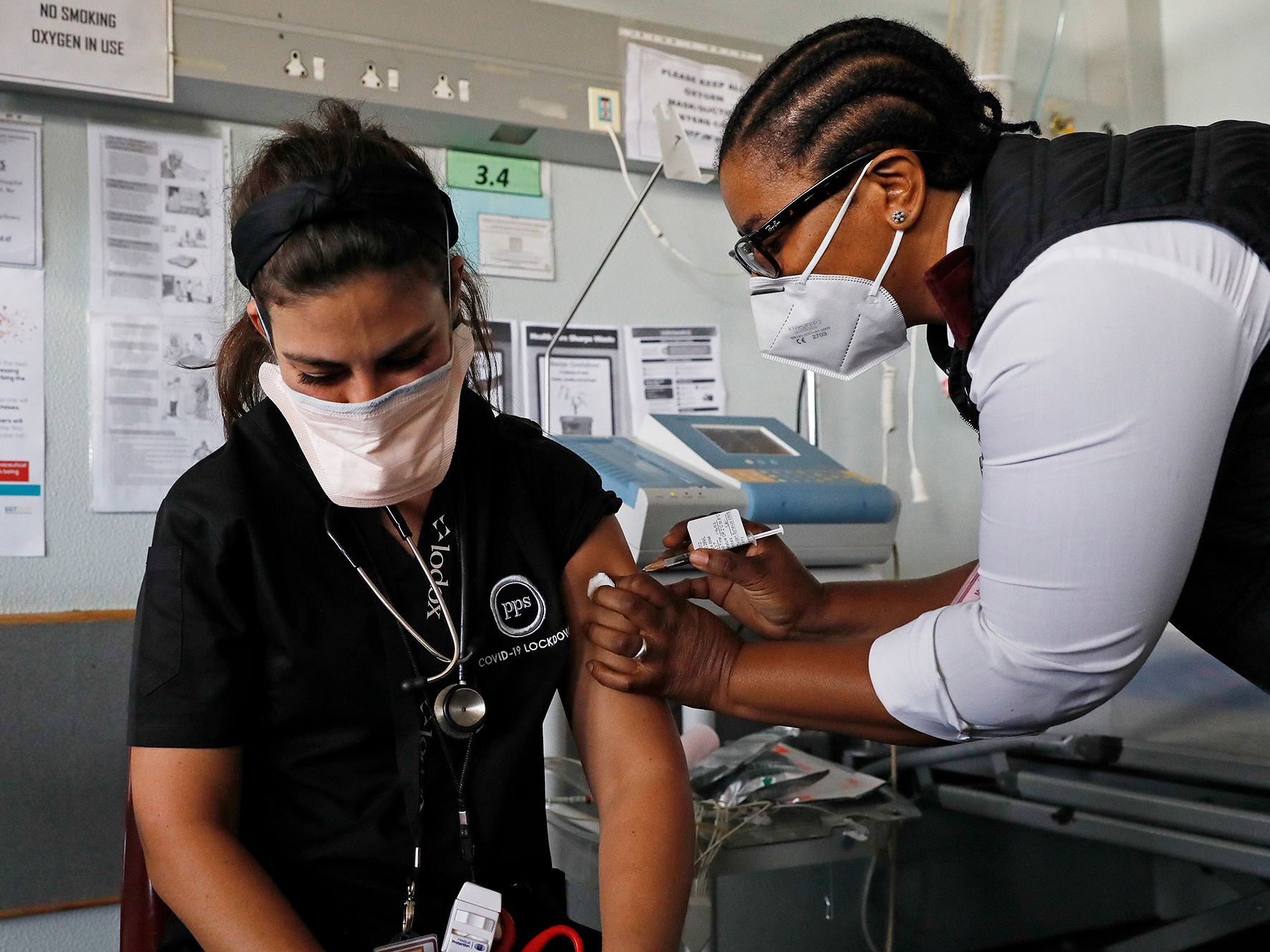 caption: Dr. Anike Baptiste receives a dose of J&J from nurse Mokgadi Malebye at a Pretoria hospital last February. South Africa is one of the countries that announced a pause on the J&J vaccine while more research is done into potential blood clots that occurred in younger women after getting the vaccine.