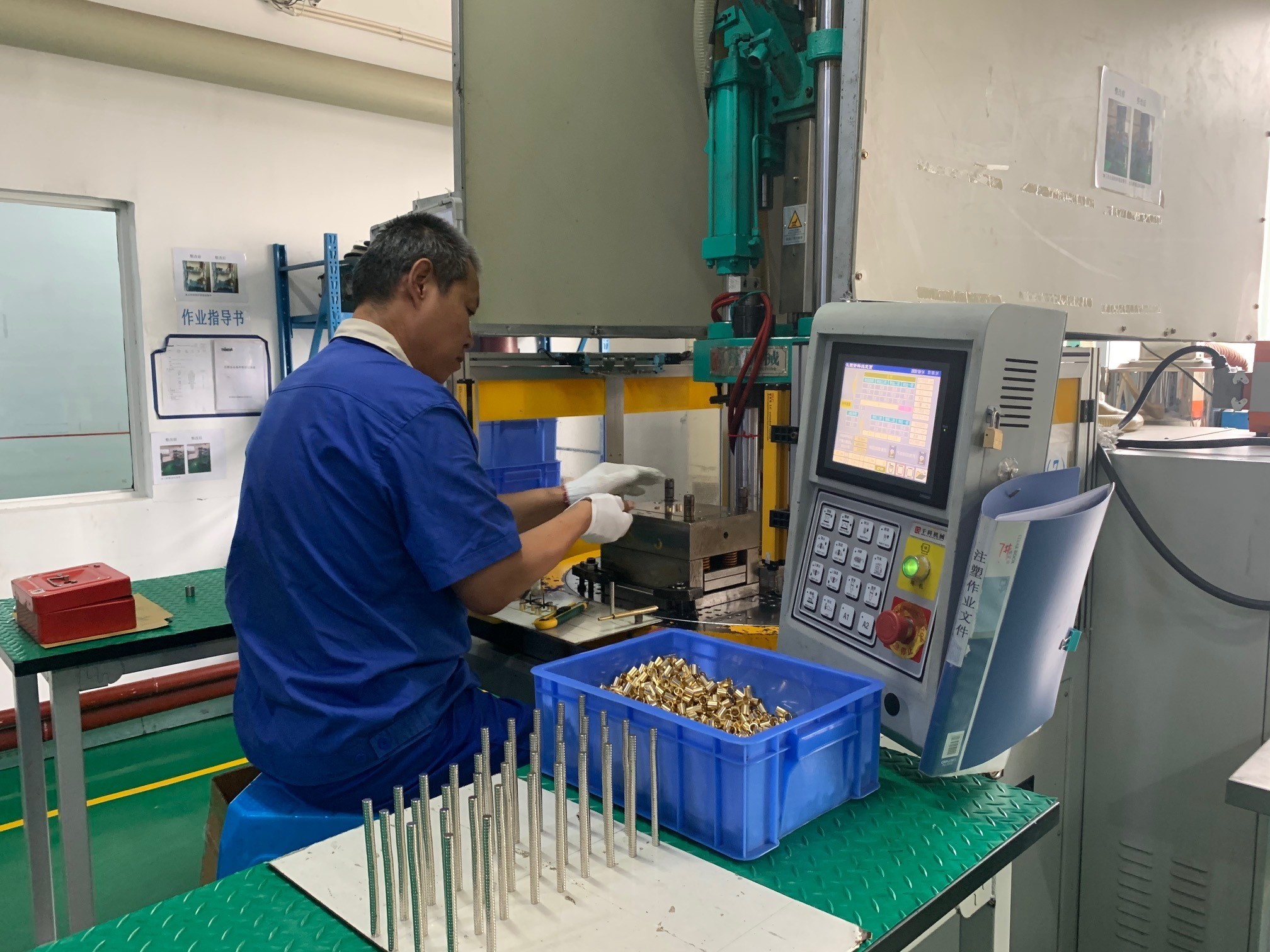 caption: A worker at Thinova Magnet Co. Ltd. puts rare earth magnets into a press at a factory in Zhejiang province.