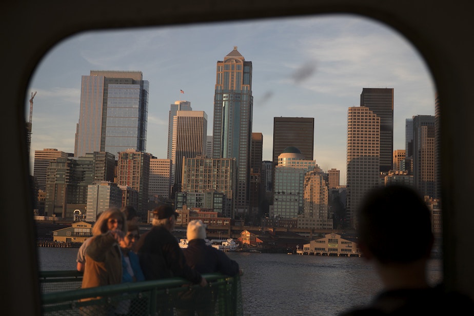 caption: Ferry riders look toward downtown Seattle shortly before arriving from Bremerton on a ferry on Thursday, June 29, 2017, in Seattle. 