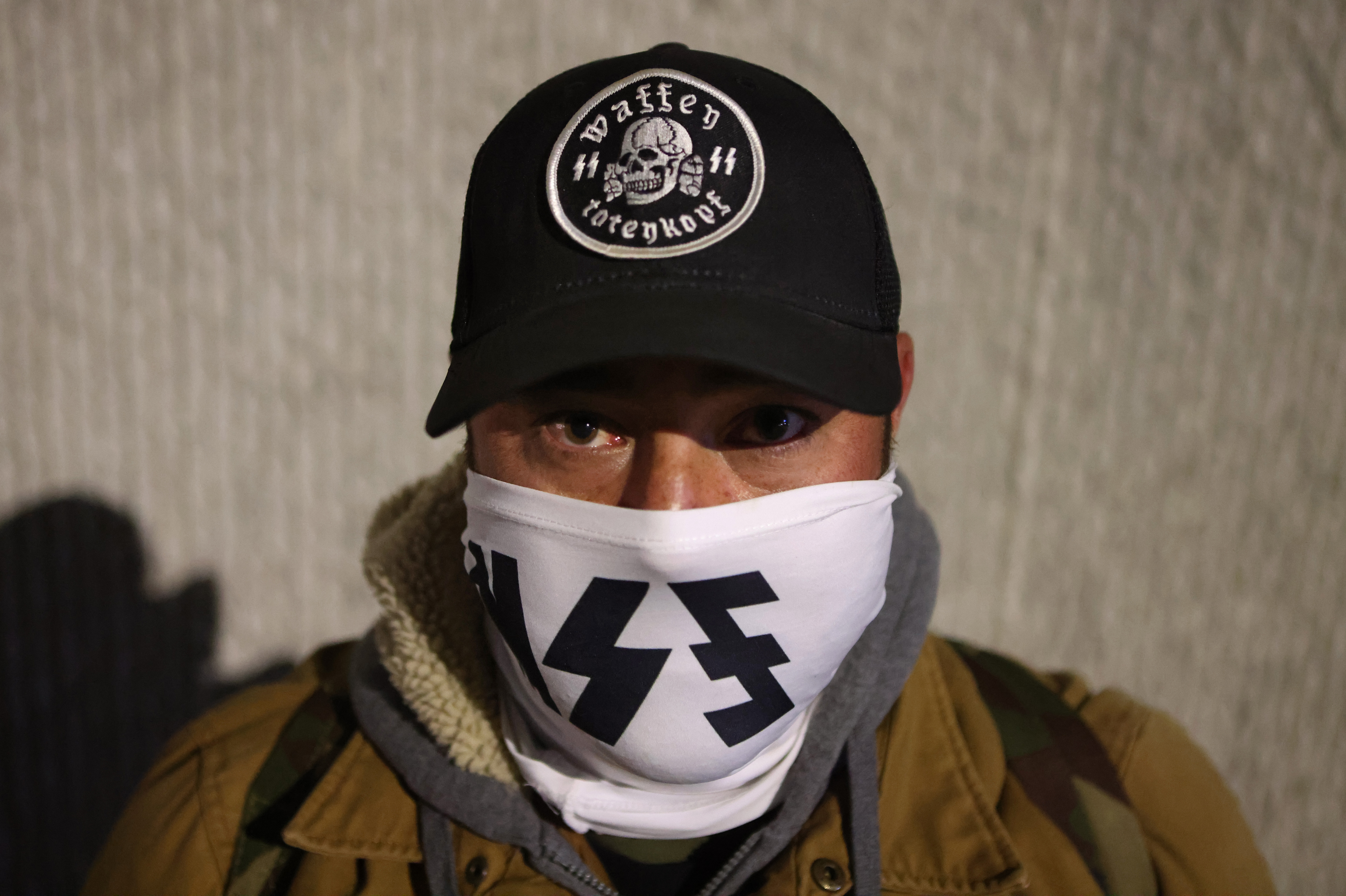 caption: Leader of white nationalist group National Socialist Florida, Josh Nunes, after the group used a laser projector to display white nationalist and anti-LGBTQ images on the sides of high-rise buildings in Jacksonville on Jan. 14.