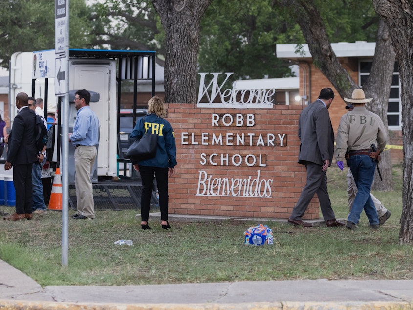 caption: Law enforcement work the scene on Tuesday after a mass shooting at Robb Elementary School in Uvalde, Texas.