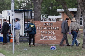 caption: Law enforcement work the scene on Tuesday after a mass shooting at Robb Elementary School in Uvalde, Texas.
