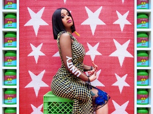 caption: Hassan Hajjaj, born in Morocco in 1961, is often called the Andy Warhol of Marrakesh for his fusion of glamour and everyday life. Both are evident in his 2017 portrait <em>Cardi B Unity. </em>The rap star, dressed in a high-fashion outfit, sits on utilitarian green plastic cartons against a textured fabric backdrop. The frame consists of tins of green tea, each decorated with a butterfly.