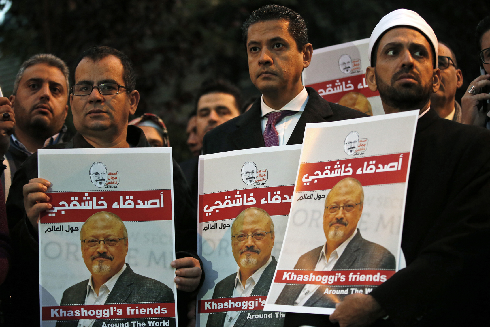 caption: Activists protesting the killing of Saudi journalist Jamal Khashoggi hold a candlelight vigil outside Saudi Arabia's consulate in Istanbul, Thursday, Oct. 25, 2018. The posters read in Arabic:' Khashoggi's Friends Around the World'. (Lefteris Pitarakis/AP)