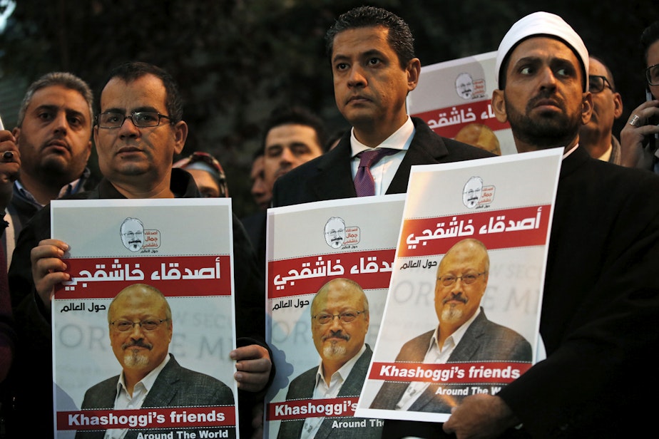caption: Activists protesting the killing of Saudi journalist Jamal Khashoggi hold a candlelight vigil outside Saudi Arabia's consulate in Istanbul, Thursday, Oct. 25, 2018. The posters read in Arabic:' Khashoggi's Friends Around the World'. (Lefteris Pitarakis/AP)