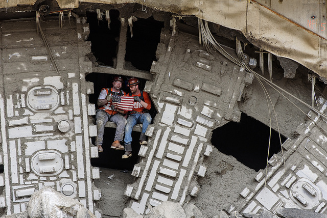 caption: Members of Bertha's crew pose after the tunneling machine broke into the disassembly pit, near Seattle's Space Needle, on April 4, 2017.