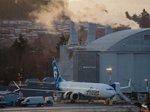 caption: Boeing workers at the Renton Municipal Airport in Wash. finalize assembly of an Alaska Airlines Boeing 737 Max jet on Feb. 27, 2024. An FAA audit faulted Boeing for "multiple instances" of quality control shortcomings.