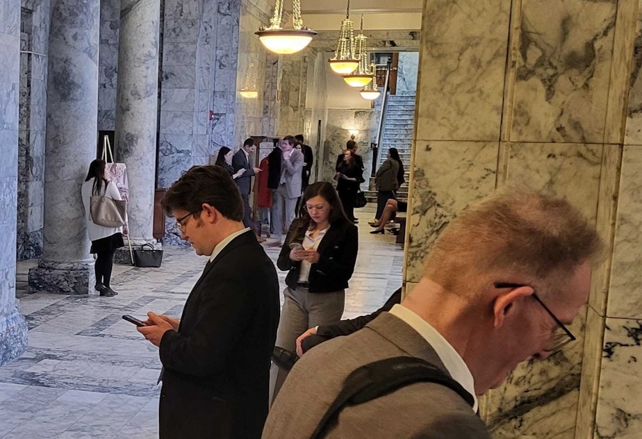 caption: Lobbyists and others outside the Washington state Senate wings in Olympia on Tuesday, April 22, 2025.