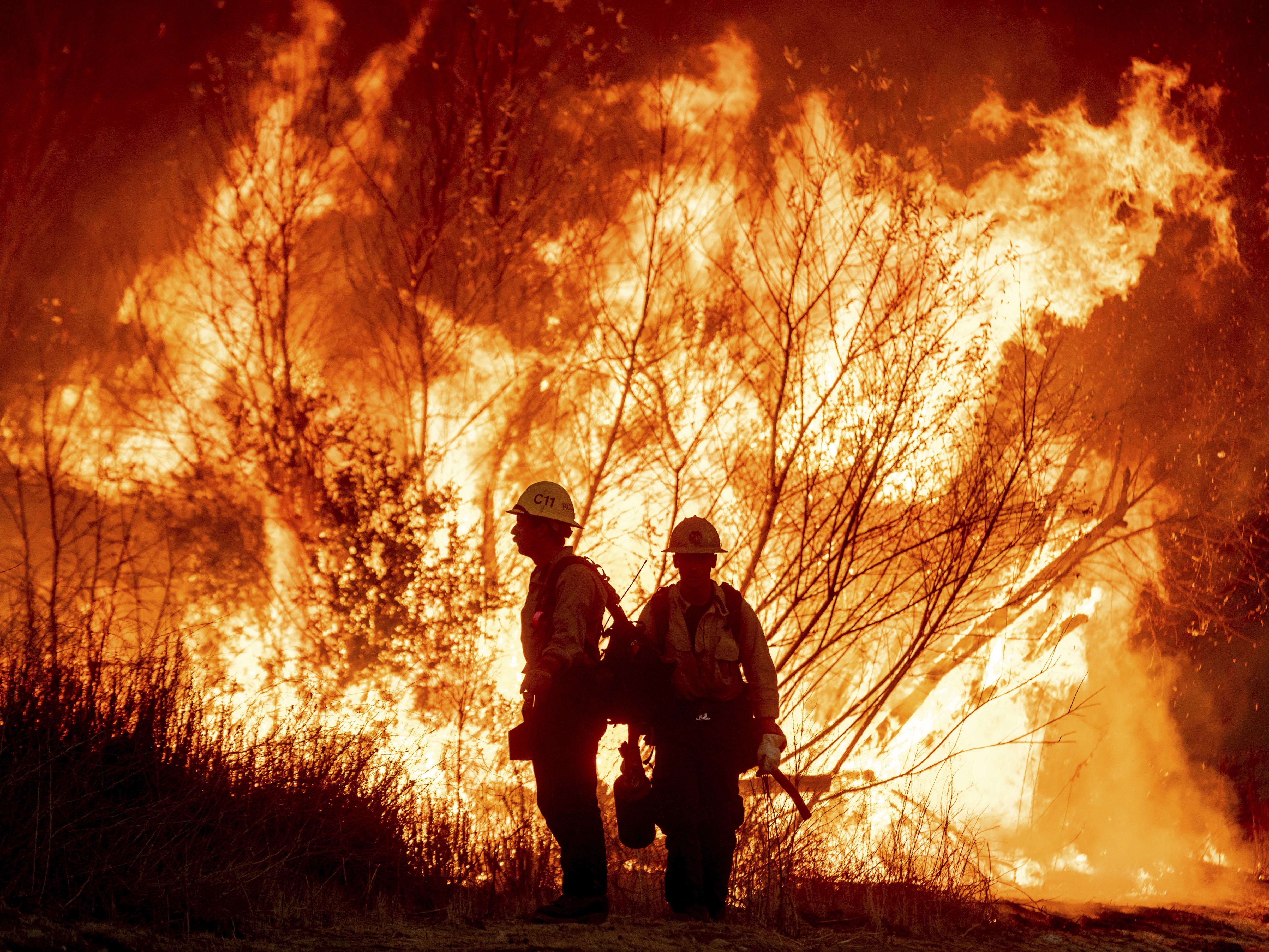 caption: Fire crews battle the Kenneth Fire in the West Hills section of Los Angeles on Thursday.